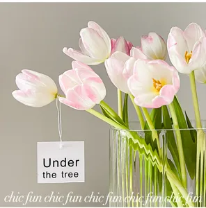 Vase en verre transparent nordique avec arrangement de tulipes artificielles.