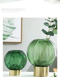 Detailed close-up of ribbed green glass vase with metallic base, modern home decor.