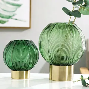Nordic green glass sphere vase with gold metal base, elegant modern home decor flower vessel.