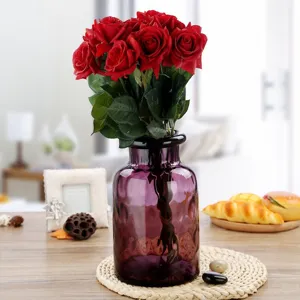 Modern minimalist purple glass flower vase with red roses bouquet for home decor.