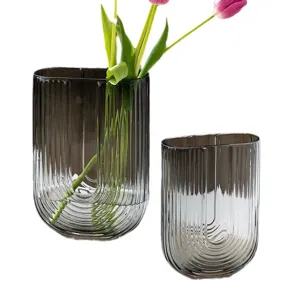 Smoke gray vertical striped U-shaped glass vase set with fresh tulips for home decor.