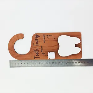 Holz-Zahnfee-Türhänger mit Lineal zur Größenbestimmung, ca. 25 cm lang.