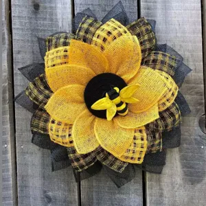 Gros plan d'une couronne de tournesol en maille rustique avec une petite abeille sur bois
