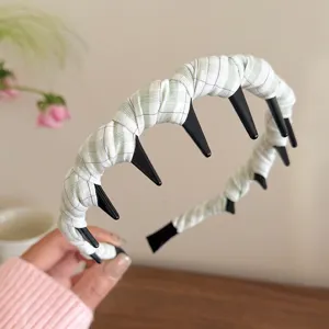 Green and white plaid headband with teeth, detail view showing fabric wrapped hair hoop design.