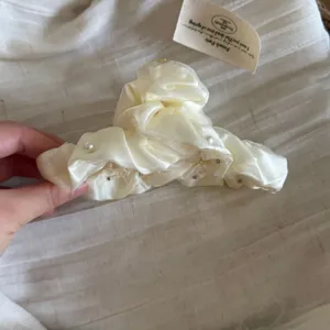 Vue détaillée de la pince à cheveux en tissu perlé double couche, accessoire élégant beige.