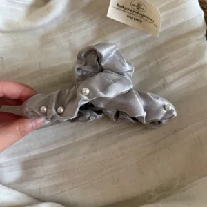 Pince à cheveux perle en tissu double couche, griffe argentée vue de détail pour femmes.