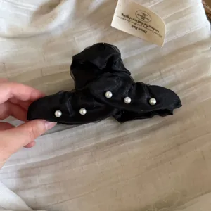 Pince à cheveux en tissu organza noir avec perles élégante pour coiffure demi-queue.