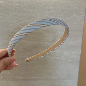 Detailansicht eines stilvollen blau gestreiften Haarreifs, elegantes Haaraccessoire.