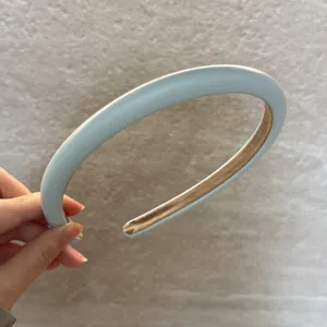 Gros plan du serre-tête en cuir crème, montrant la texture lisse et la finition soignée.