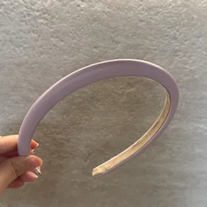 Vue rapprochée du serre-tête en cuir matelassé lavande, montrant texture et belle finition.