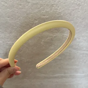Serre-tete en cuir jaune creme pour femmes, accessoire de coiffure doux et polyvalent, design elegant.