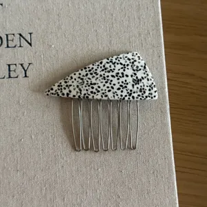 Triangle acetate hair insert comb detail, stylish black white dotted pattern side hair pin tool.