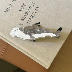 Vue détaillée d'une pince à cheveux requin marteau unique, accessoire élégant en acétate pour femme.