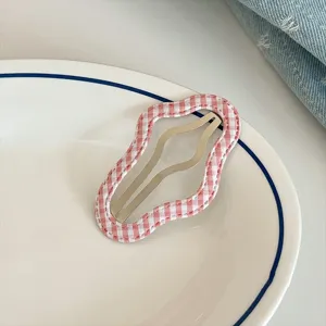 Pink and white plaid wavy hair clip detail shot, sweet style accessory for bangs and styling.