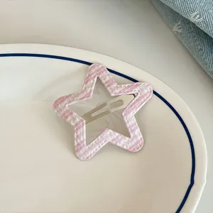 Close-up detail of a sweet pink plaid star hair clip, cute hair accessory for daily styling.
