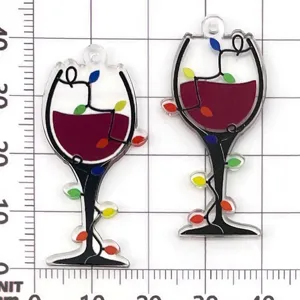 Close-up detail of black and red acrylic wine glass charm pendant with colorful lights pattern.