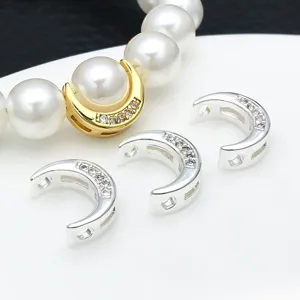 Detailed close-up of gold and silver moon spacer beads with sparkling zirconia for DIY jewelry.