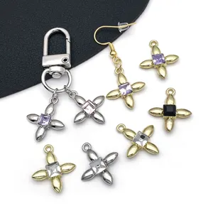 Detailed view of DIY alloy clover charms, square crystal pendants, and keychains in gold.