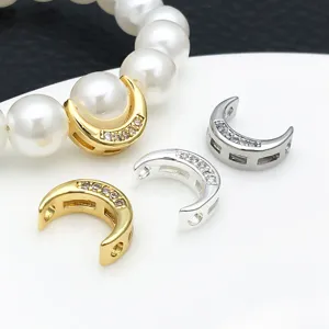 Detail view of gold and silver moon shaped zircon inlaid spacer beads for DIY jewelry making.