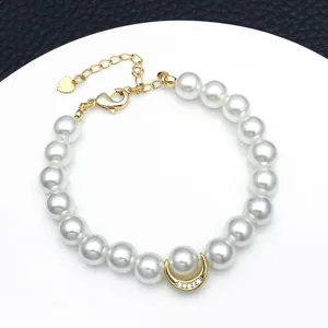 Elegant white pearl bracelet featuring a gold-toned crescent moon charm with sparkling zirconia details.