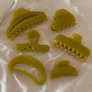 Détail rapproché de pinces à cheveux gel olive vert translucide, formes chics variées.