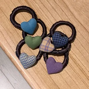 Detalle de coletero de corazón a cuadros estilo coreano, accesorios de tela coloridos.
