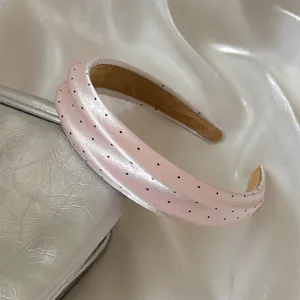 Primer plano detalle diadema lunares satén rosa, bonita vista textura accesorio cabello.