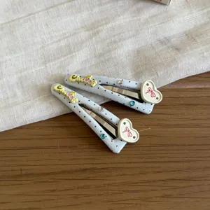 Primer plano detallado de pinzas de pelo de tela con lunares, cerezas y lazos lindos.