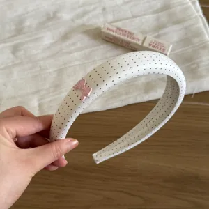 Dulce diadema de tela de topos blancos con lazo rosa, hermosa vista detallada.