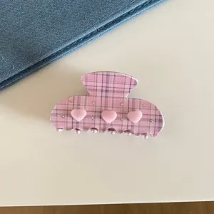Pince à cheveux à carreaux rose avec de jolis cœurs et strass, accessoire très élégant.