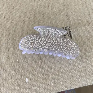 Pince à cheveux en acétate strass, design nœud cristal scintillant, accessoire élégant.