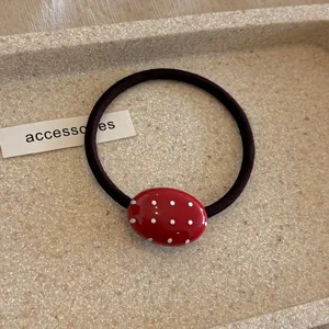 Minimalistische haarelastiek met rode polka dot ovale kraal voor dagelijks gebruik.
