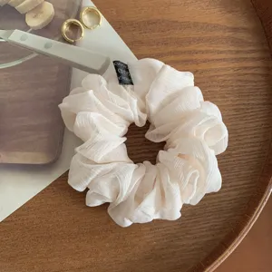 Vista dettagliata di un elastico per capelli in chiffon bianco con etichetta, chic ed elegante.