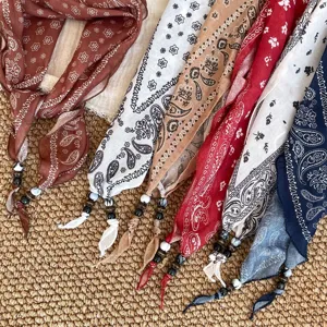 Detailopname van kleurrijke paisley halsdoeken met kralen kwastjes aan het uiteinde voor stijl.