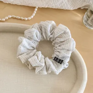 Vue détaillée de l'élastique à cheveux en tissu à pois frais artistiques, accessoire chic.