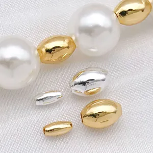 Close-up detail of DIY jewelry making components, metallic gold and silver beads with white pearls.