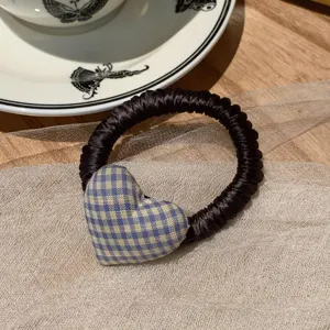 Detalle de coletero de corazón a cuadros con tela azul y amarilla para coletas de caballo diarias.