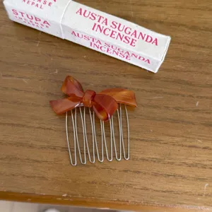 Brown acetate bow hair comb with metal tines, elegant and chic hair accessory for daily styling.