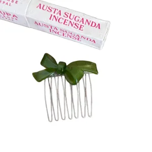Green acetate bow hair comb with metal tines, elegant vintage hair accessory for women styling.