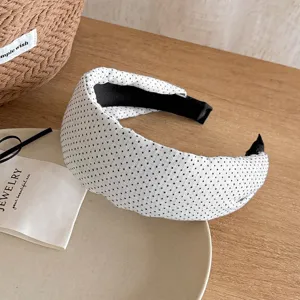 Dettaglio di un cerchietto largo a pois in stile francese, elegante accessorio in tessuto.