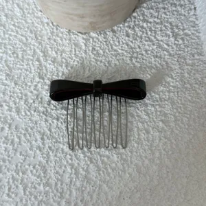 Detailed view of elegant acetate bow hair comb, stylish hair accessory for women styling.