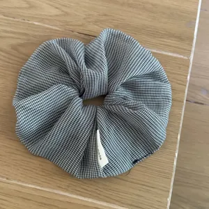 Close-up detail of a black and white gingham sheer scrunchie showcasing the fine fabric texture.