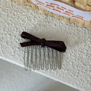 Vista detallada peine para pelo lazo acetato, diseño marrón oscuro con dientes de metal.