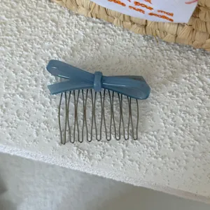 Vista detallada del peine para cabello con lazo de acetato azul, elegante accessorio.