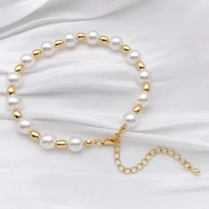 Detailed close-up view of elegant gold and white pearl beaded bracelet with extender chain.