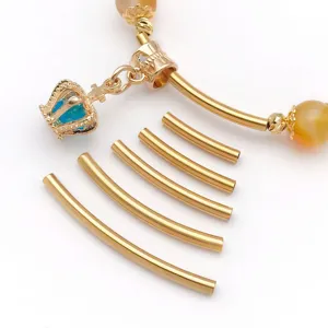 Detailed close-up of gold stainless steel curved noodle tubes and crown pendant DIY parts.