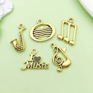 Gros plan de charms musicaux dorés antiques, pendentifs saxophone et notes pour bijoux DIY.