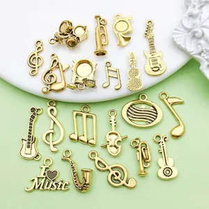 Gros plan de charms d'instruments de musique en or ancien pour la création de bijoux DIY.