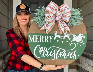 Rundes Weihnachts-Türschild aus Holz mit Merry Christmas Schriftzug, Rentieren und großer Schleife