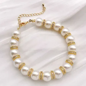 Detailansicht eines eleganten künstlichen Perlenarmbands mit glänzenden Strassgoldabstandhaltern.